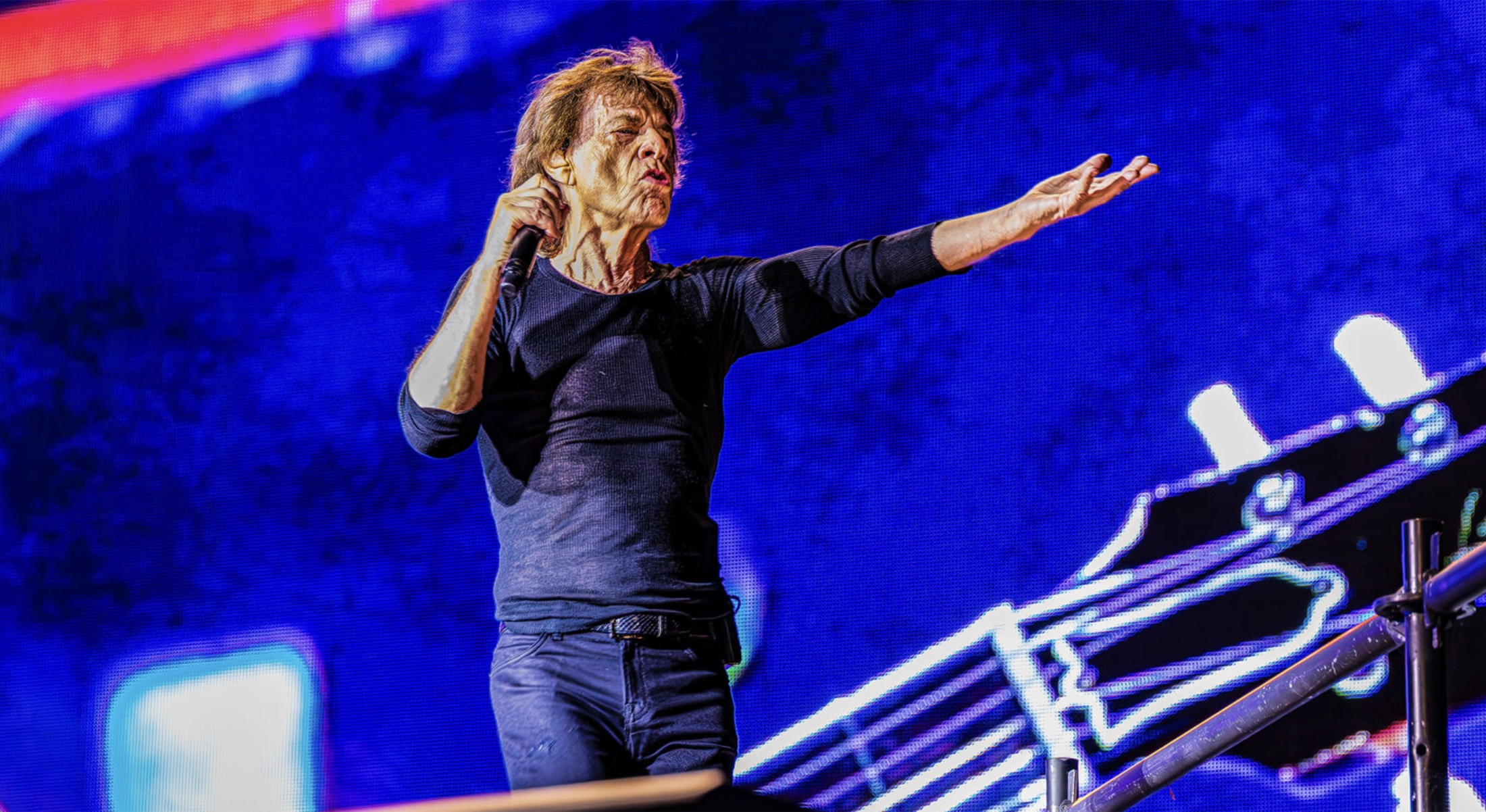 Mick Jagger performing in front of a blue concert screen during the Hackney Diamonds tour