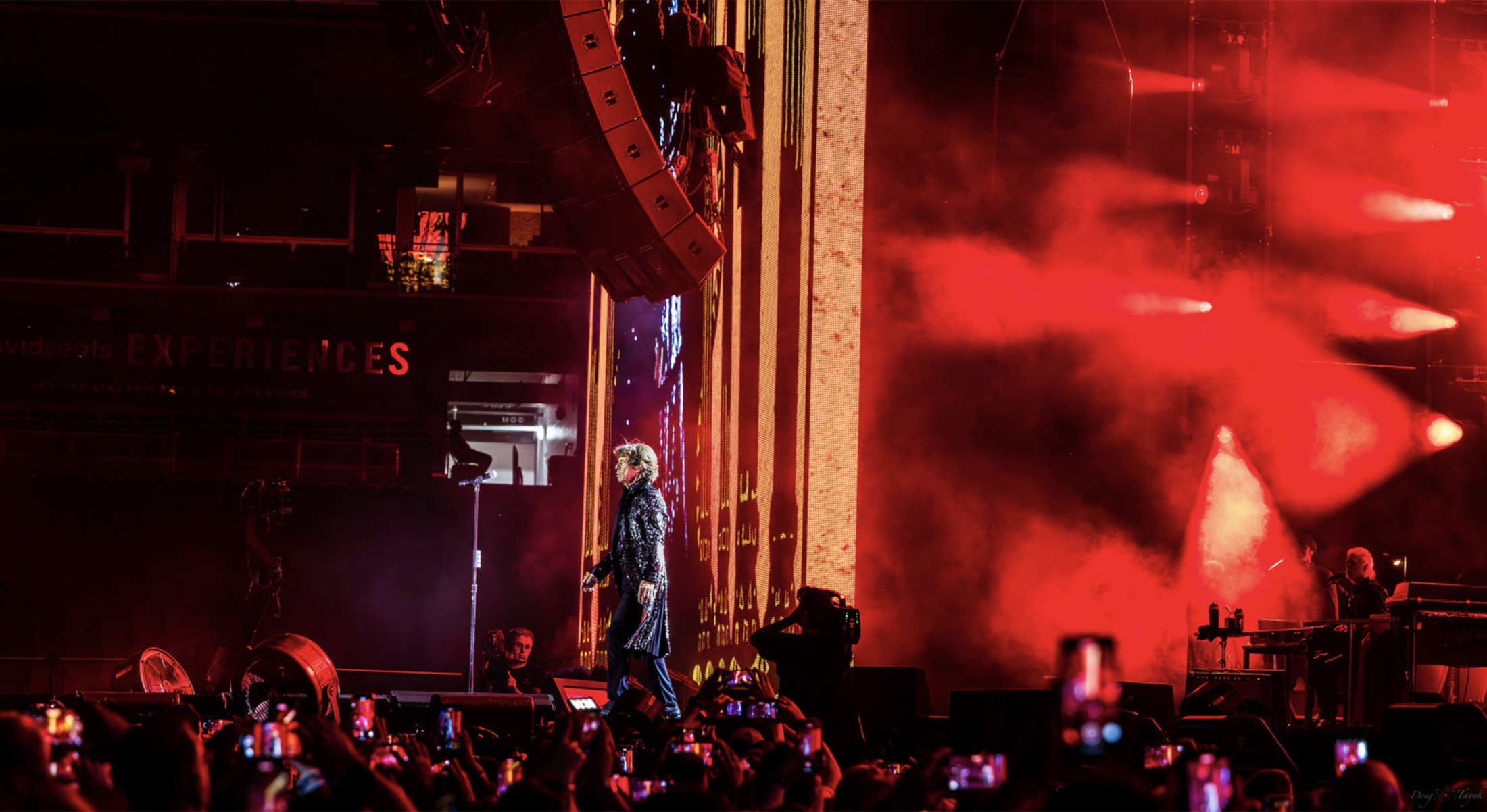 The Rolling Stones performing under red stage lighting during the Hackney Diamonds tour